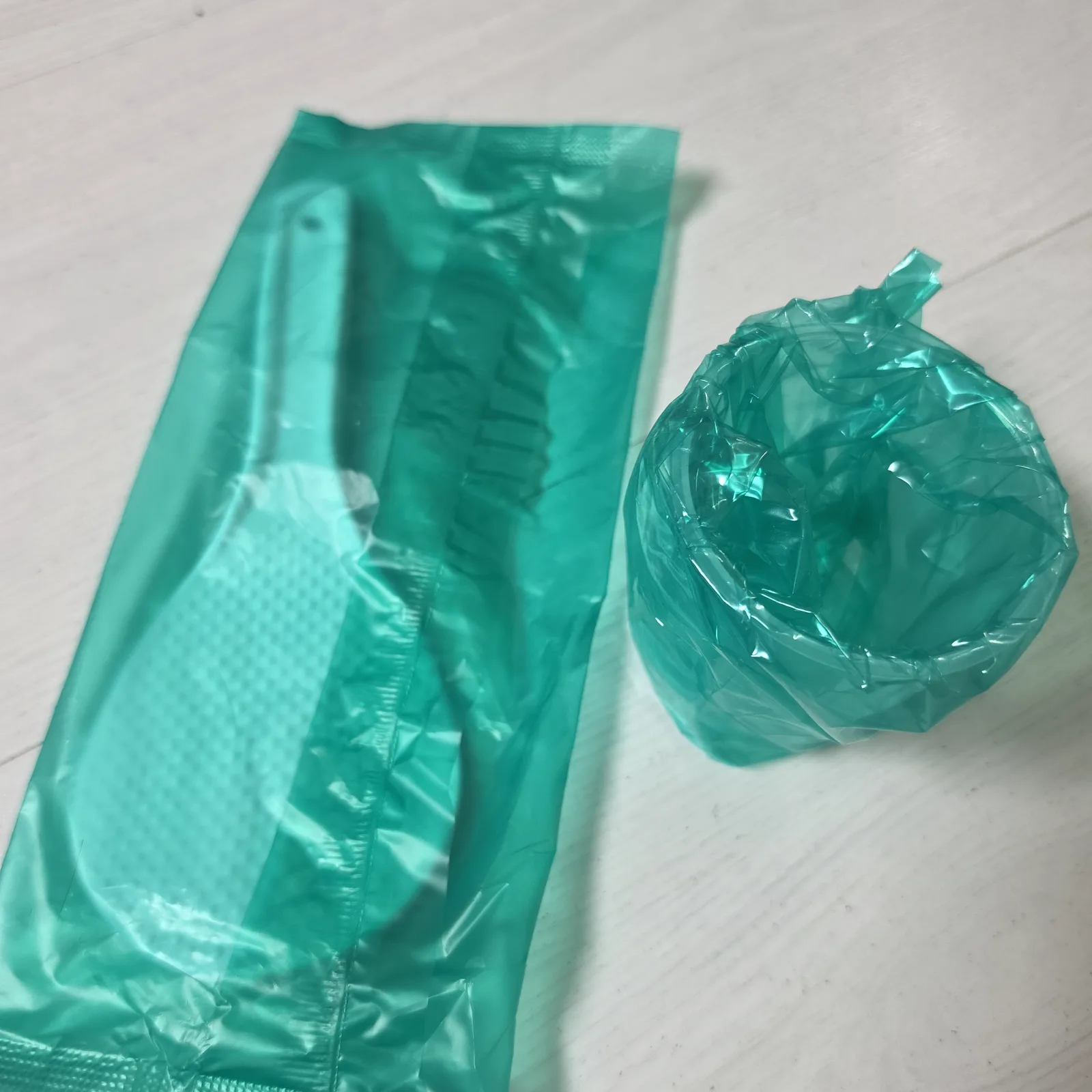 초록 비닐에 개별 포장된 쿠쿠 밥솥 전용 주걱과 계량컵