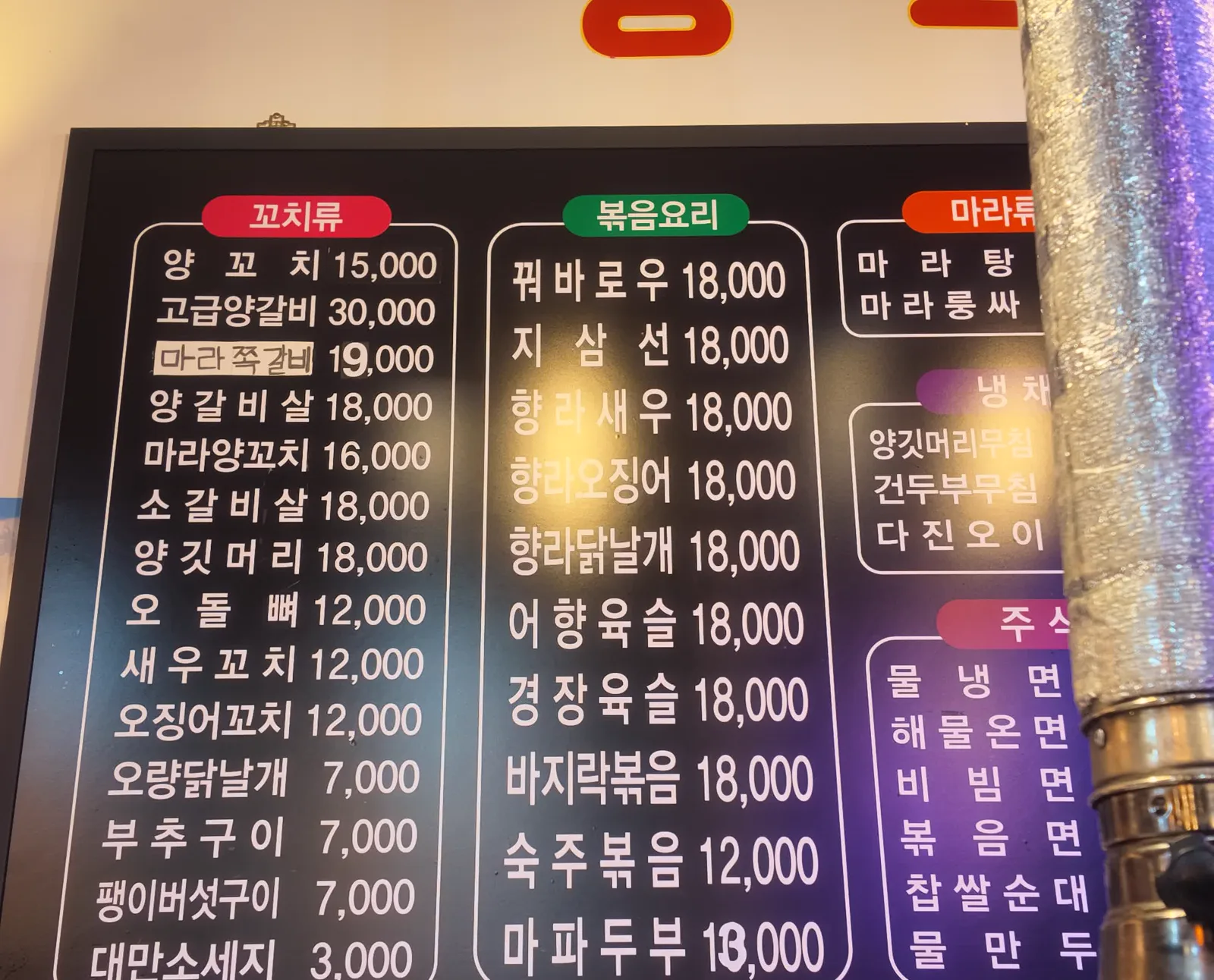 꼬치류와 볶음요리 가격이 적힌 메뉴판 클로즈업, 양꼬치 15000원 지삼선 18000원